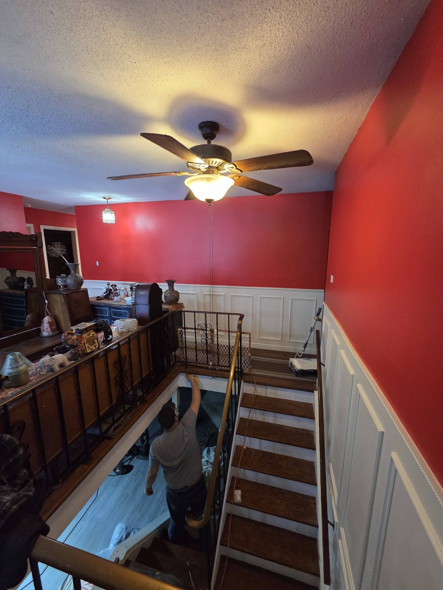 Stairwell with red accent wall and white wainscoting